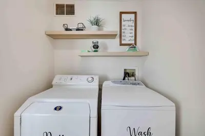 a laundry room with a washer and dryer and shelves at Cozy Poconos Mountain House with 3 bedrooms in Tobyhanna