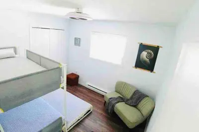 a bedroom with a bed and a couch and a chair at Cozy Poconos Mountain House with 3 bedrooms in Tobyhanna