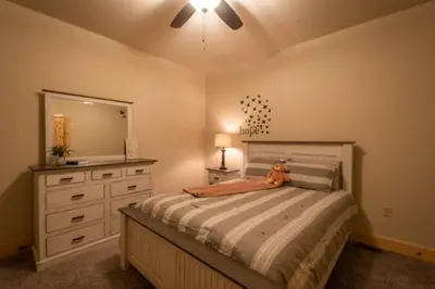 a bedroom with a bed with a dresser and a mirror at The Mountain Lodge in Elliottsburg