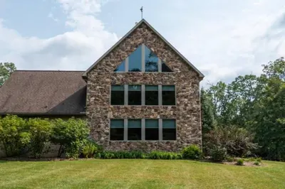 a stone house with a large window at The Mountain Lodge in Elliottsburg