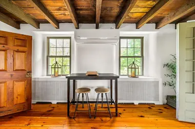 a dining room with a table and two stools at Downingtown Manor - 1900s Farmhouse with Creek Views in Downingtown