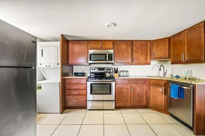 a kitchen with wooden cabinets and stainless steel appliances at Downingtown Manor - 1900s Farmhouse with Creek Views in Downingtown