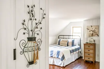 a bedroom with a bed and a vase with flowers at Downingtown Manor - 1900s Farmhouse with Creek Views in Downingtown