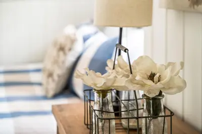 two vases with flowers in them on a table at Downingtown Manor - 1900s Farmhouse with Creek Views in Downingtown