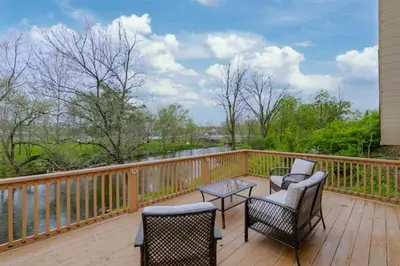 a wooden deck with chairs and a table on it at Boat House in Downingtown