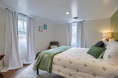 a bedroom with a large bed with green and white pillows at 5 bd w Hottub - mins to Hunting Hiking & Fishing in New Providence