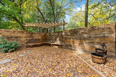 a wooden bench sitting in a yard next to a fence at 5 bd w Hottub - mins to Hunting Hiking & Fishing in New Providence