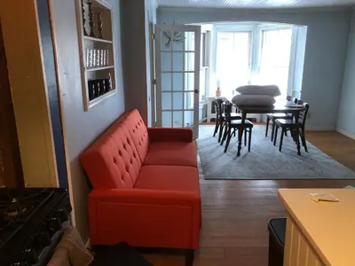 a living room with a red couch and a table at Slumberland at the River's Edge in Pond Eddy