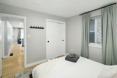 a white bedroom with a bed and a window at 2BR in Heart of Queen Village - walk to everything! in Philadelphia