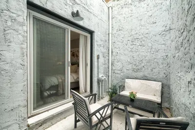 a patio with a table and chairs and a window at 2BR in Heart of Queen Village - walk to everything! in Philadelphia