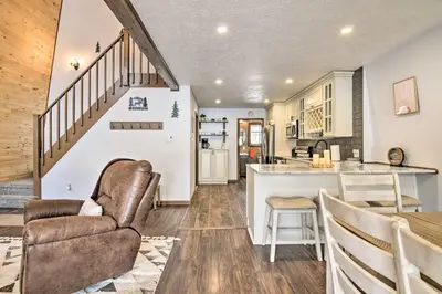 a kitchen and living room with a couch and a table at Tobyhanna Cabin with Deck, Community Pool and Golf! in Tobyhanna