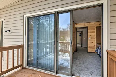 a sliding glass door on a house with a balcony at Tobyhanna Cabin with Deck, Community Pool and Golf! in Tobyhanna