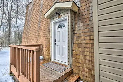 a white door on a brick house with a wooden ramp at Tobyhanna Cabin with Deck, Community Pool and Golf! in Tobyhanna