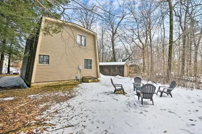 a group of chairs in the snow in front of a house at Tobyhanna Cabin with Deck, Community Pool and Golf! in Tobyhanna