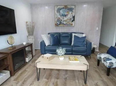 a living room with a blue couch and a coffee table at Catskills Cottage with Lake View Book Now in Rock Hill