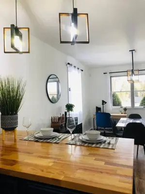 a living room with a wooden table and a dining room at Catskills Cottage with Lake View Book Now in Rock Hill