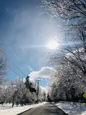 a road covered in snow with the sun in the sky at Catskills Cottage with Lake View Book Now in Rock Hill