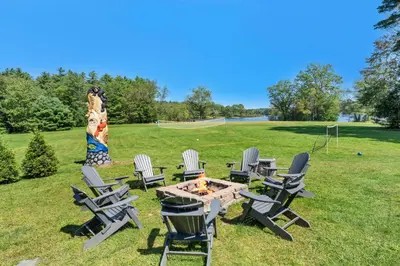 a group of chairs and a table with a fire pit at 2 Lake Cabins Poolhottub Game Room & Courts in Highland Lake