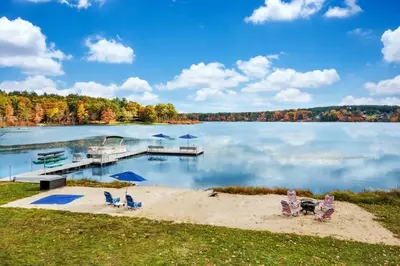 a view of a lake with a dock and chairs at 2 Lake Cabins Poolhottub Game Room & Courts in Highland Lake