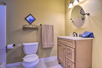 a bathroom with a toilet and a sink and a mirror at 1 Mi to Lake Family-Friendly Tobyhanna Home in Tobyhanna