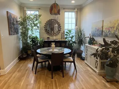 a dining room with a table and chairs and plants at 5BRwithBand&Piano setup Private Gym Theater&Entry at Cherry Hill in Cherry Hill