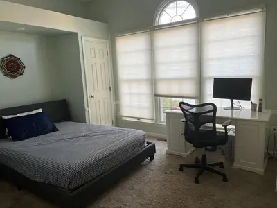 a bedroom with a bed and a desk and a chair at 5BRwithBand&Piano setup Private Gym Theater&Entry at Cherry Hill in Cherry Hill