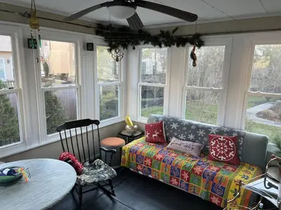 a living room with a couch and a table and windows at 5BRwithBand&Piano setup Private Gym Theater&Entry at Cherry Hill in Cherry Hill