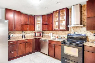a kitchen with wooden cabinets and a stove top oven at Highland Hideaway in East Stroudsburg