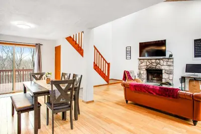 a living room with a couch and a table and a fireplace at Highland Hideaway in East Stroudsburg
