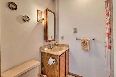 a bathroom with a sink and a toilet and a mirror at about 1 Mi to Lake Secluded Poconos Home with Decks in Jim Thorpe