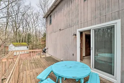 a patio with a blue table on a deck at about 1 Mi to Lake Secluded Poconos Home with Decks in Jim Thorpe