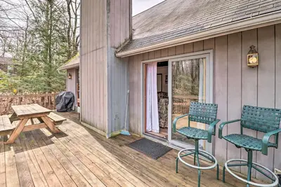 two chairs and a picnic table on a wooden deck at about 1 Mi to Lake Secluded Poconos Home with Decks in Jim Thorpe