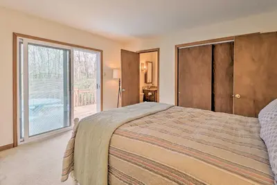 a bedroom with a bed and a sliding glass door at about 1 Mi to Lake Secluded Poconos Home with Decks in Jim Thorpe