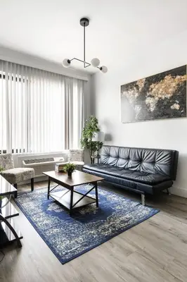 a living room with a black leather couch and a blue rug at Luxury Apartments - Newark Int Airport - Evonify Stays in Elizabeth