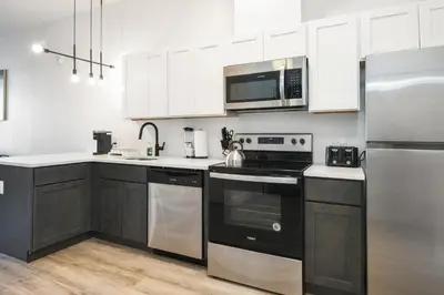 a kitchen with white cabinets and a stove top oven at Luxury Apartments - Newark Int Airport - Evonify Stays in Elizabeth