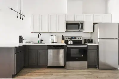 a kitchen with black appliances and white cabinets at Luxury Apartments - Newark Int Airport - Evonify Stays in Elizabeth