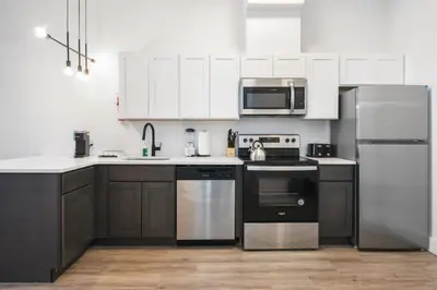 a kitchen with black appliances and white cabinets at Luxury Apartments - Newark Int Airport - Evonify Stays in Elizabeth