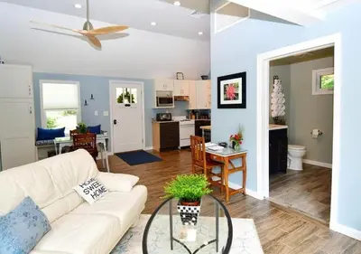 a living room with a white couch and a table at Cottage at Millpond Falls - A Romantic Escape in Warwick