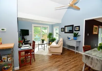 a living room with blue walls and a ceiling fan at Cottage at Millpond Falls - A Romantic Escape in Warwick