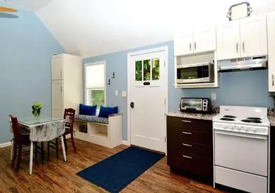 a kitchen with a table and a dining room at Cottage at Millpond Falls - A Romantic Escape in Warwick