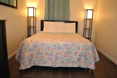 a bedroom with a bed with a colorful bedspread at MOTELCASA Guest House Newark NJ in Newark