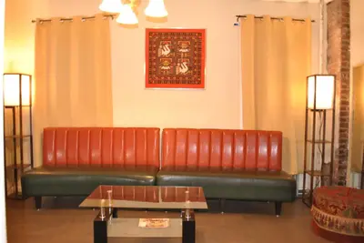 two red leather couches sitting in a waiting room at MOTELCASA Guest House Newark NJ in Newark