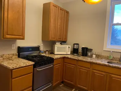 a kitchen with a stove and a microwave at MOTELCASA Guest House Newark NJ in Newark