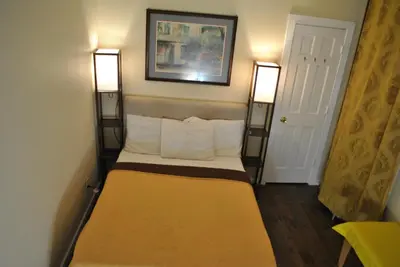 a small bed in a room with two lights on at MOTELCASA Guest House Newark NJ in Newark