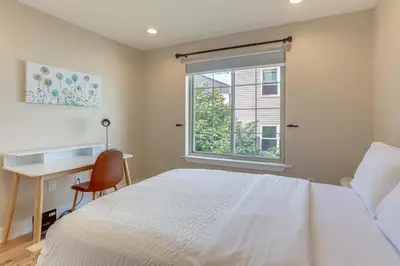 a bedroom with a bed and a desk and a window at 3-Story Philly Townhouse 2 Mi to University City! in Philadelphia