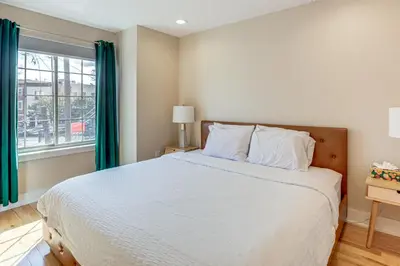 a bedroom with a large bed and a window at 3-Story Philly Townhouse 2 Mi to University City! in Philadelphia