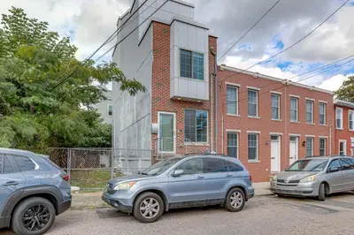 three cars parked in a parking lot in front of a building at 3-Story Philly Townhouse 2 Mi to University City! in Philadelphia