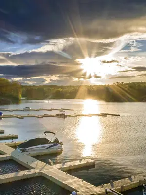 a sunset over a lake with boats in the water at Elmwood Elmwood Escape A Cozy Retreat at The Hideout in Hamlin