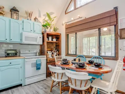 a kitchen with blue cabinets and a table and chairs at Elmwood Elmwood Escape A Cozy Retreat at The Hideout in Hamlin