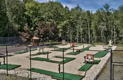 a park with a playground with green swings at Elmwood Elmwood Escape A Cozy Retreat at The Hideout in Hamlin